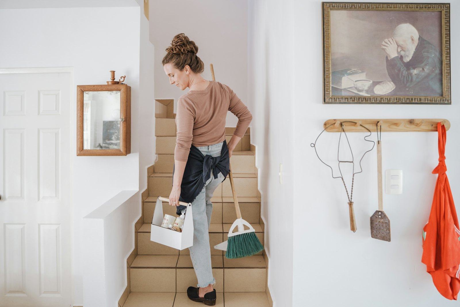 Cleaner carrying supplies up the stairs
